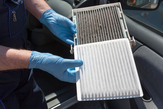 Replacing the pollen air filter. Old and new cabin air filter for a car.