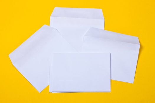 white open envelopes on the yellow background