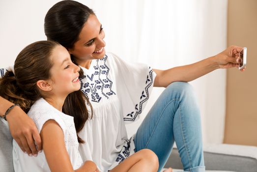 Beautiful Mom and Daughter at home making a selfie