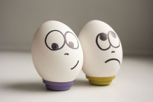 Pessimist and optimist concept. Eggs with painted face. photo for your design