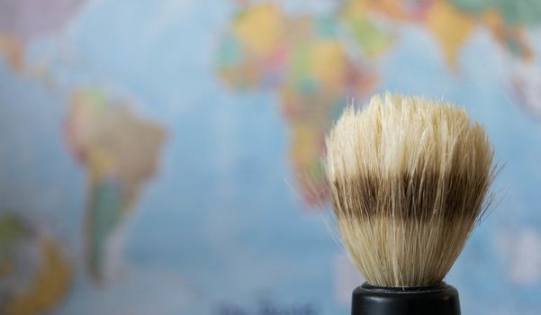 old style shaving brush on a world map background.