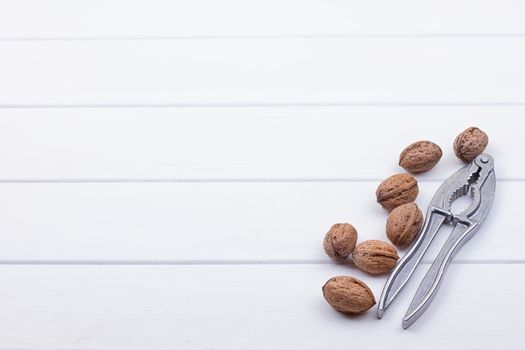 many walnuts on the white wooden background with copy-space