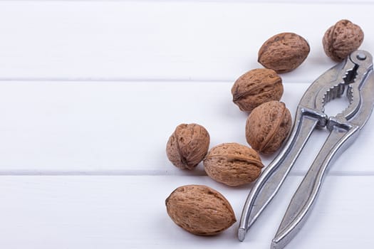 many walnuts on the white wooden background with copy-space