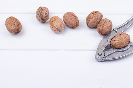 many walnuts on the white wooden background with copy-space
