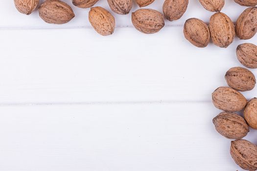 many walnuts on the white wooden background with copy-space