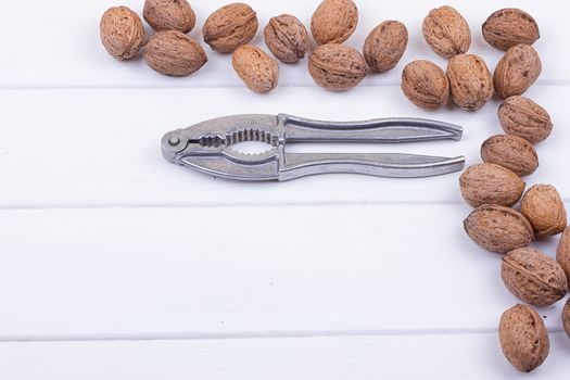 many walnuts on the white wooden background with copy-space