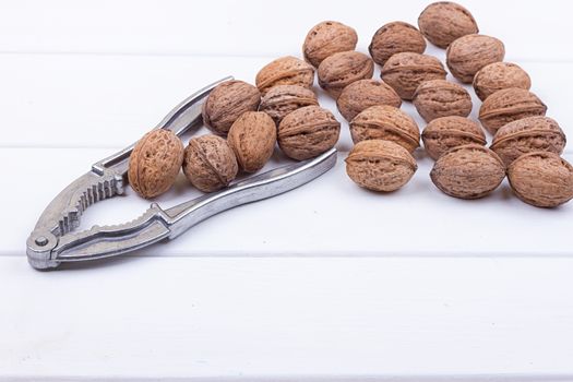 many walnuts on the white wooden background with copy-space