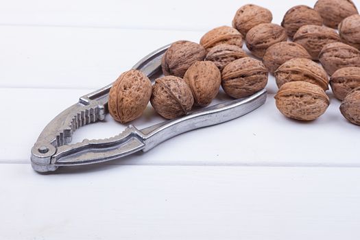 many walnuts on the white wooden background with copy-space