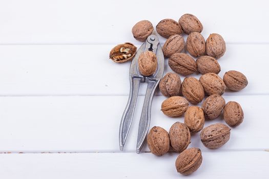 many walnuts on the white wooden background with copy-space