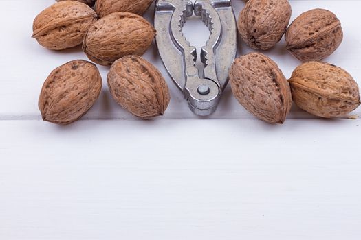 many walnuts on the white wooden background with copy-space