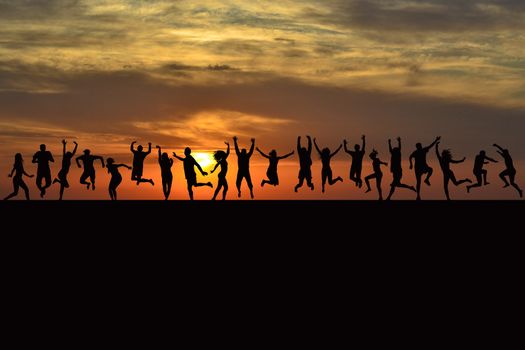 Happy men and women silhouettes jumping at sunrise