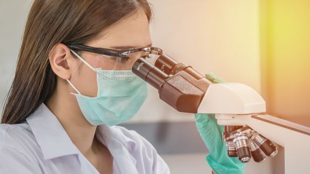 scientist looking through a microscope in a laboratory