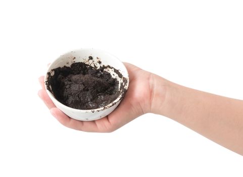 Woman's hand holding bowl of coffee grounds for skin scrub, health care and beauty concept