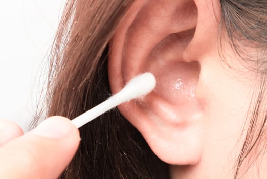 Closeup woman cleaning ear with cotton bud, health care concept