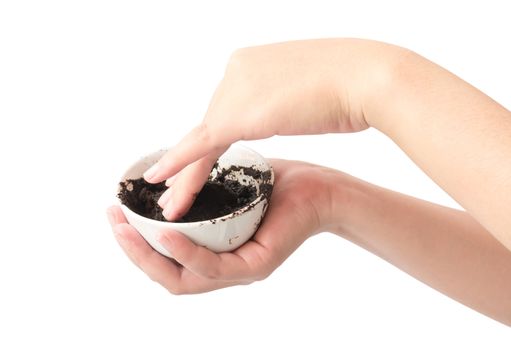 Woman's hand holding bowl of coffee grounds for skin scrub, health care and beauty concept