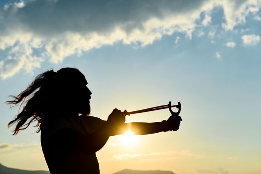 silhouette of the man who throws slingshot