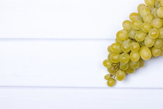 White grapes on white wooden surface. top view. copy-space