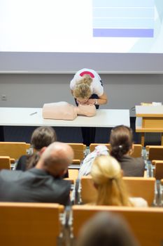 Instructor teaching first aid cardiopulmonary resuscitation course and use of automated external defibrillator on voluntary public workshop for senior people.