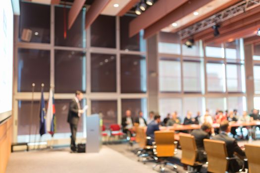 Speaker giving a talk on corporate business event. Audience at the conference hall. Business and Entrepreneurship event. Out of focus image. Unrecognizable business people.