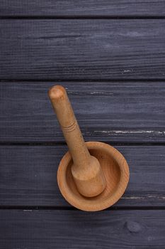 Handmade wooden mortar on the black background