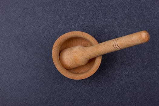 Handmade wooden mortar on the black background