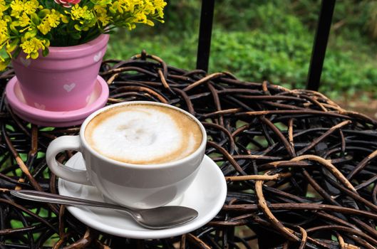 Cup of hot latte on wood tabable with nature background