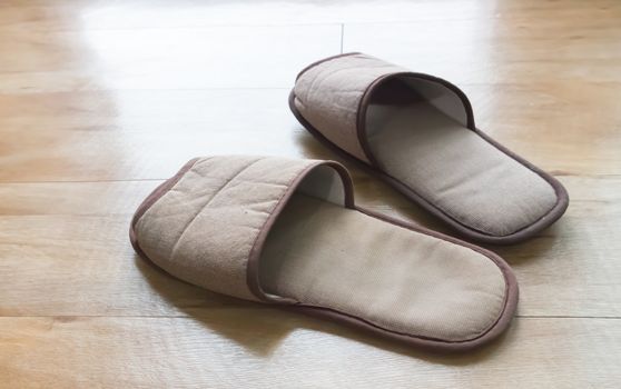 Brown house slippers on wood floor, relax concept