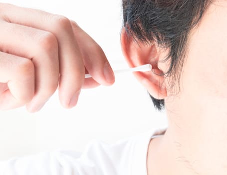 Closeup man cleaning ear with cotton bud, health care concept