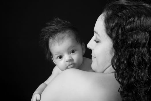 Mother with her one month baby girl on black background