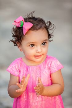 Baby girl dressed in pink clapping