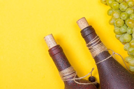 bottle of white wine with grapes on a yellowbackground