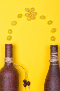 White grapes are poured into stone bottles on a yellow background