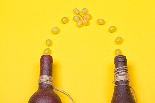 White grapes are poured into stone bottles on a yellow background