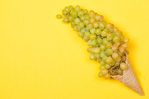 Grapes in the ice waffle on yellow background