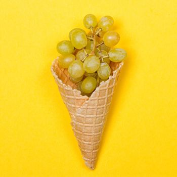 Grapes in the ice waffle on yellow background