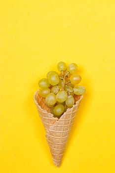 Grapes in the ice waffle on yellow background