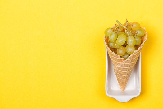 Grapes in the ice waffle on yellow background