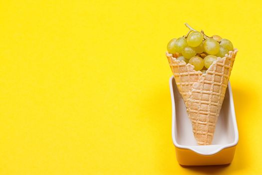 Grapes in the ice waffle on yellow background