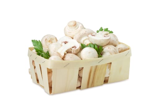 Fresh cultivated button mushrooms with twigs of parsley in the wooden basket on a white background 
