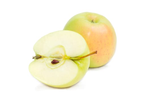 One whole and one cut in half with seeds of the green and yellow apples on a white background
