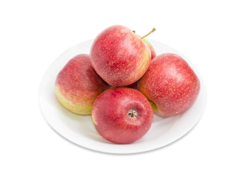 Several red ripe apples on a white dish on a white background closeup 
