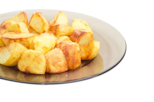 Fragment of the dark glass dish with country style fried potatoes on a light background
