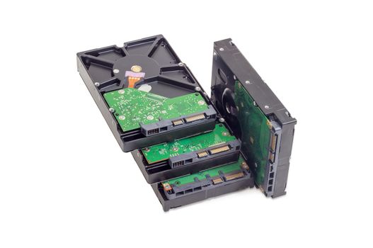 Several different SATA hard disk drives for use in desktop computers from the side of the electronics boards on a white background
