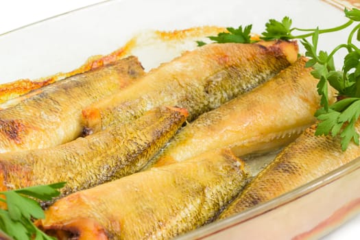 Baked notothenia fish in the glass casserole dish closeup