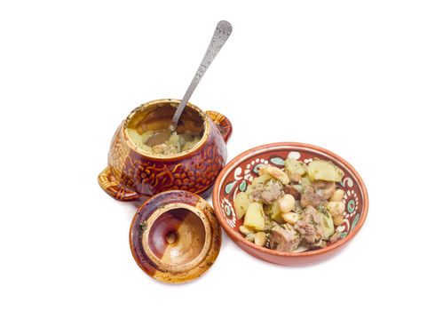 Ukrainian version of the dish Chanakhi - potatoes with meat, mushrooms and haricot beans roasted in a clay pot on a white background
