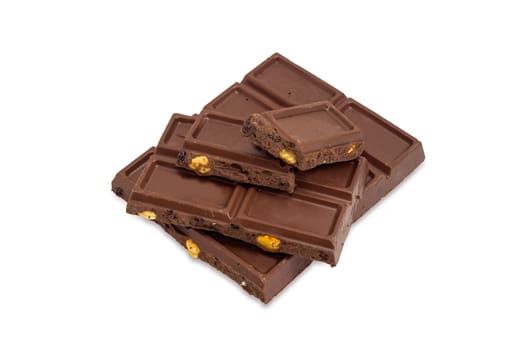 Several pieces of the milk chocolate bar with nuts and raisins on a white background
