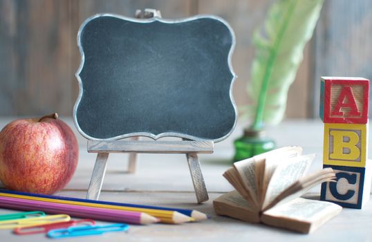 Empty blackboard with school stationery, and apple