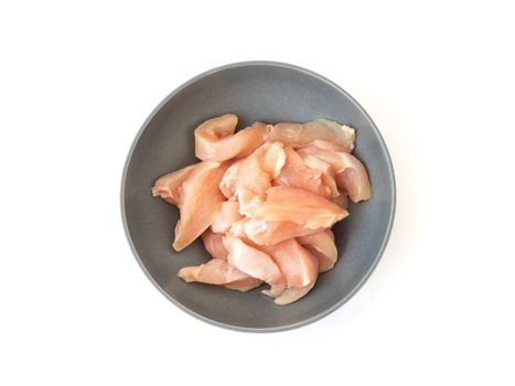 Raw cut chicken filled in the bowl on white background