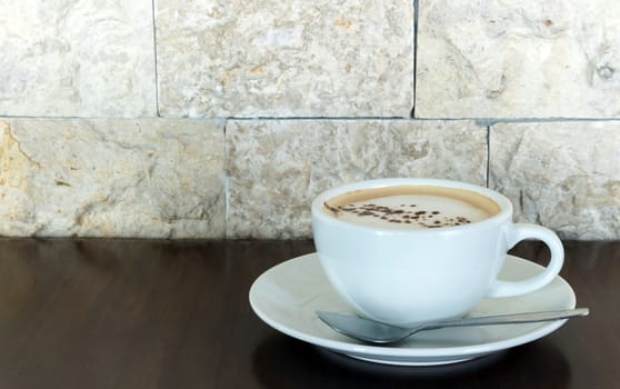 Cup of hot cappuccino on wood table in the coffee shop