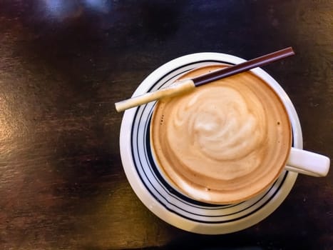 Cappuccino and water on the table with glass of water